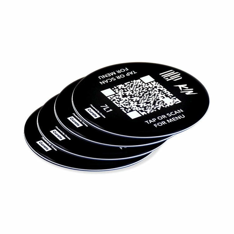 Adesivos NFC redondos em resina epóxi sobrepostos com ilustrações de código QR em leque para identidade visual durável e uso por aproximação NFC.