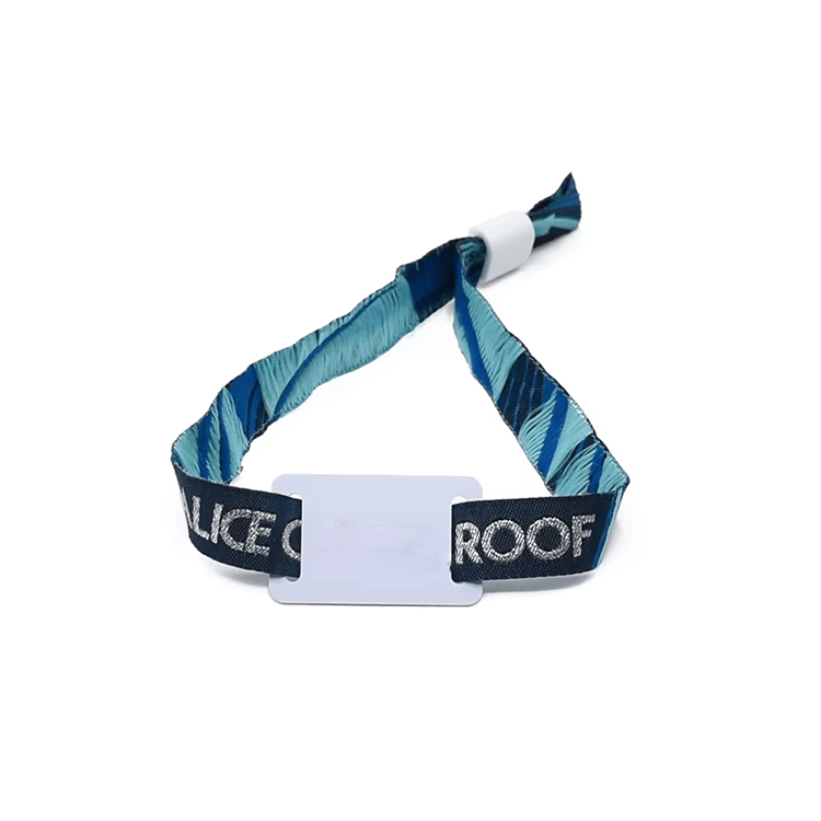 Pulseiras RFID em tecido para acesso em spas e resorts, mostradas em cenário de check-in de hóspedes.