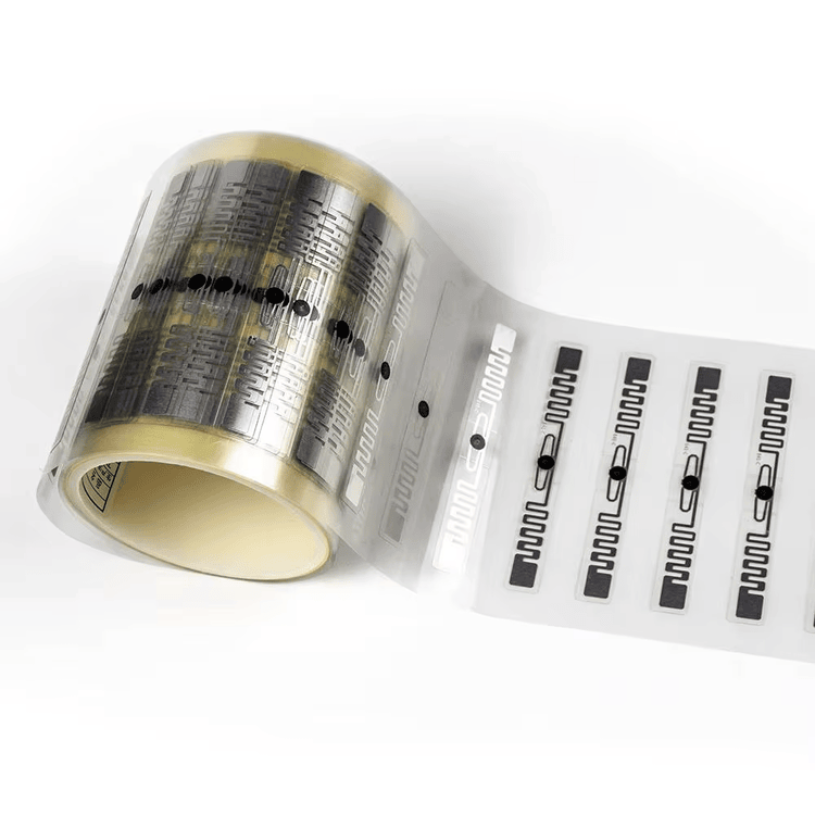 Rolo de inlays RFID com padrões de antena e marcadores pretos, preparado para conversão em grande volume em ingressos de papel.