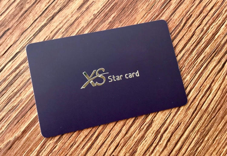 Cartões plásticos com apliques metálicos vistos pelo detalhe do logotipo impresso personalizado.