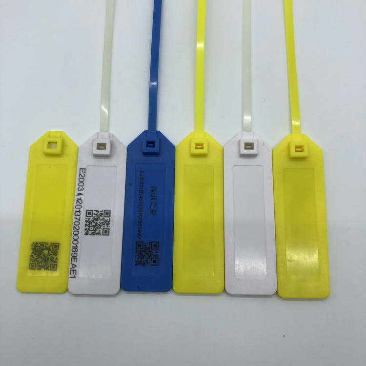 Amostras de tags RFID em amarelo, branco e azul com marcação a laser de código QR, texto fixo e áreas em branco.