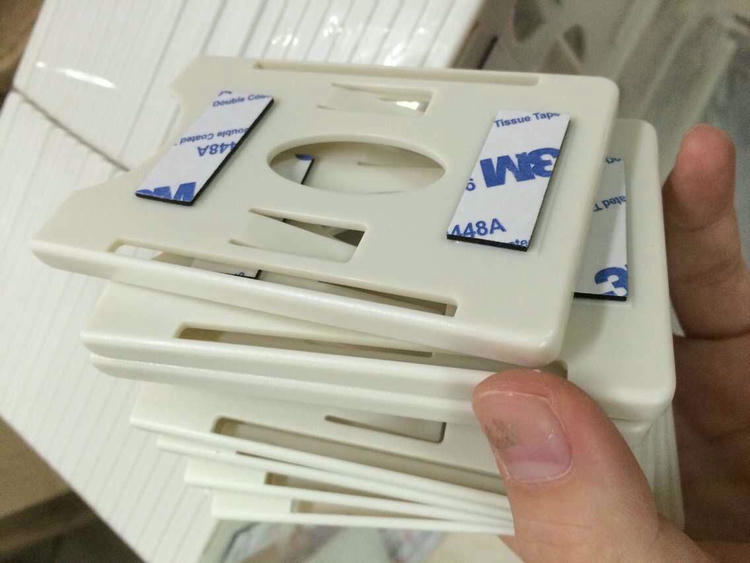 Aplicação prática do suporte autoadesivo em uma mesa de escritório para evitar a perda de crachás de funcionários.