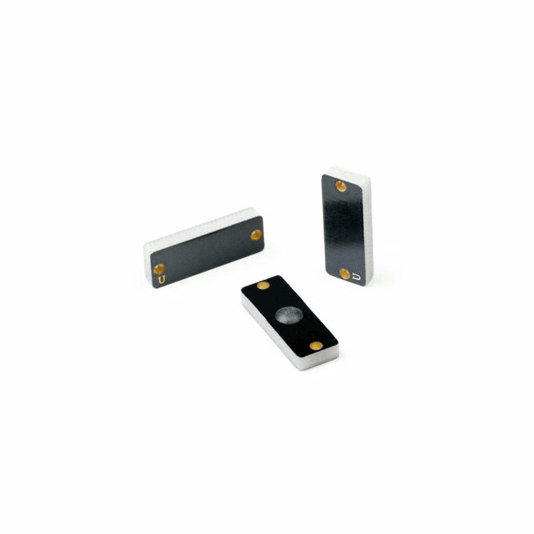 A fotografia mostra três tags RFID PCB para metal P2208-3 na posição vertical, permitindo visualizar claramente os orifícios de fixação e o perfil lateral.