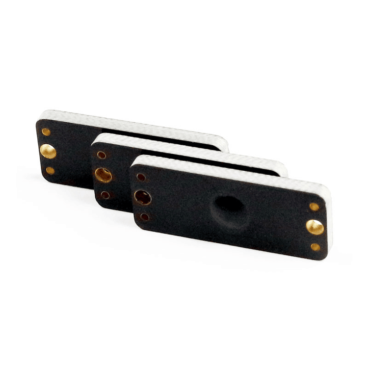 Imagem em ângulo de três tags RFID PCB para metal P2510-1 sobrepostas, mostrando a espessura das bordas e a construção resistente.
