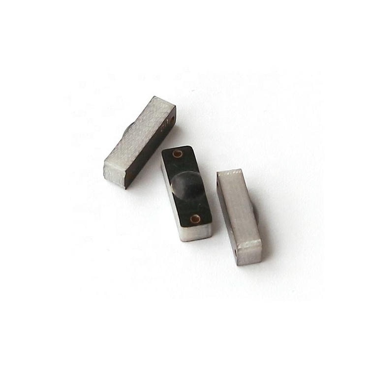 Close mostra três tags RFID PCB para metal P1204-2 com face abaulada e base metálica para rastreamento durável de equipamentos.