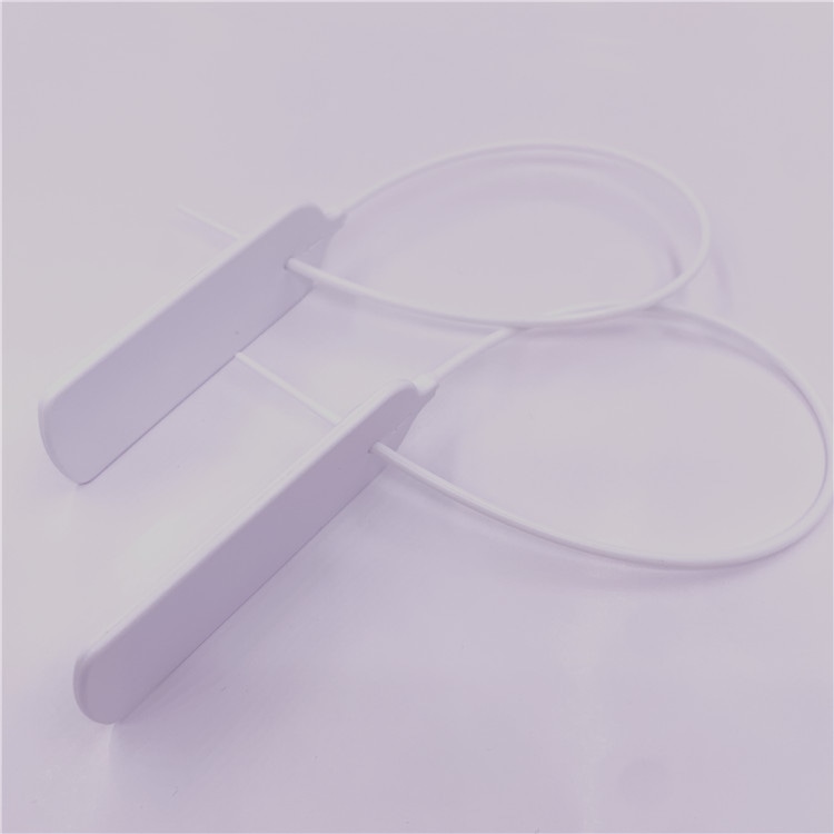 Close de duas etiquetas RFID tipo abraçadeira com lacre, modelo Z33026-1, mostrando a tira inserida no cabeçote e a face de identificação alinhada.