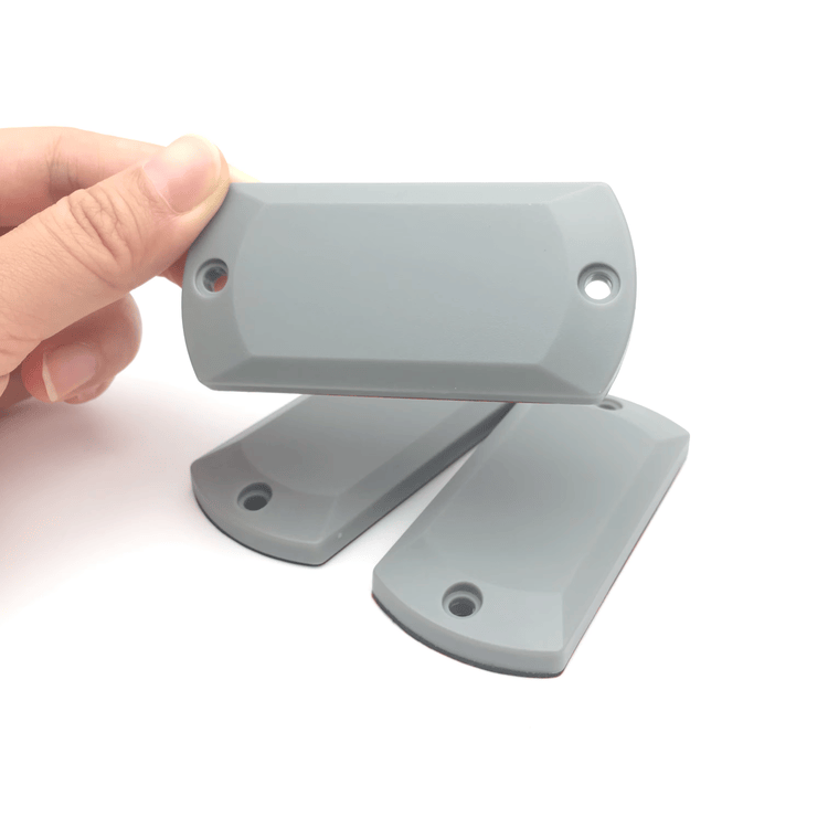 Imagem dos Tags RFID UHF ABS para Metal aplicados em superfície metálica para identificação industrial.