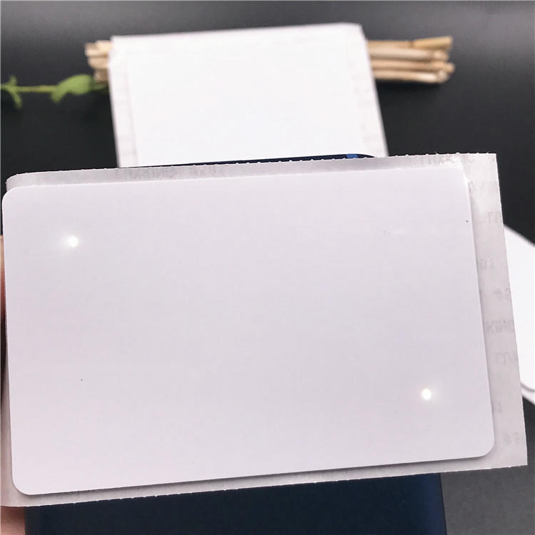 Pessoa segurando um adesivo NFC LED compacto para oferecer uma referência visual de tamanho, comparando a pequena etiqueta com uma mão humana