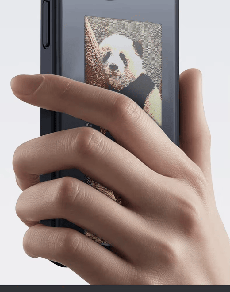 Uma mão segura uma capa NFC para celular enquanto a tela E Ink exibe uma imagem de alto contraste para identificação visual rápida.