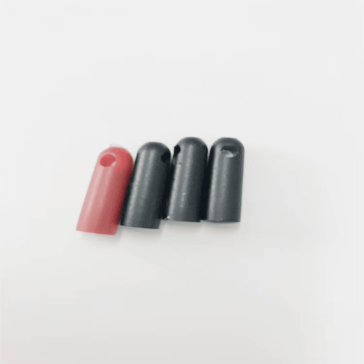 Uma tag RFID tubular vermelha e três pretas SV-005 alinhadas para demonstrar a uniformidade do corpo moldado.