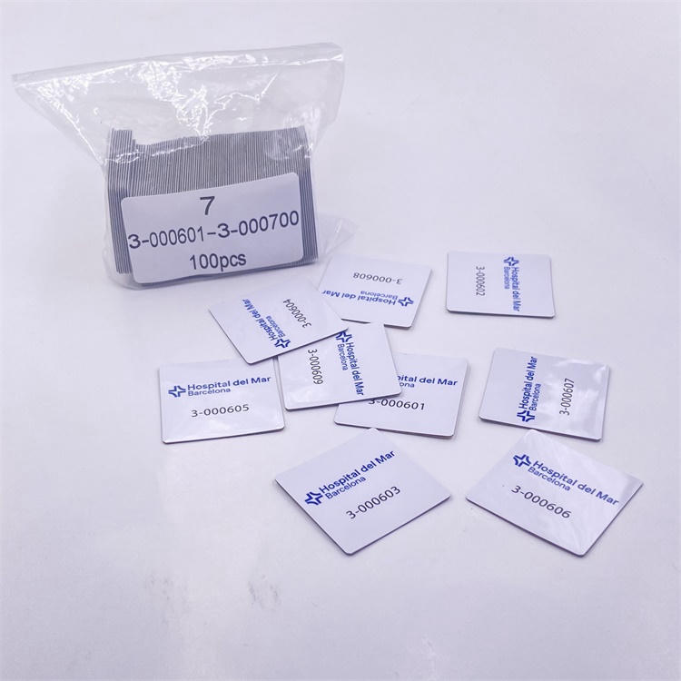 Embalagem em saco transparente com etiqueta e etiquetas RFID de PVC para superfícies metálicas soltas sobre a mesa, mostrando o acondicionamento em lote para pedidos de identificação de ativos sem contato.