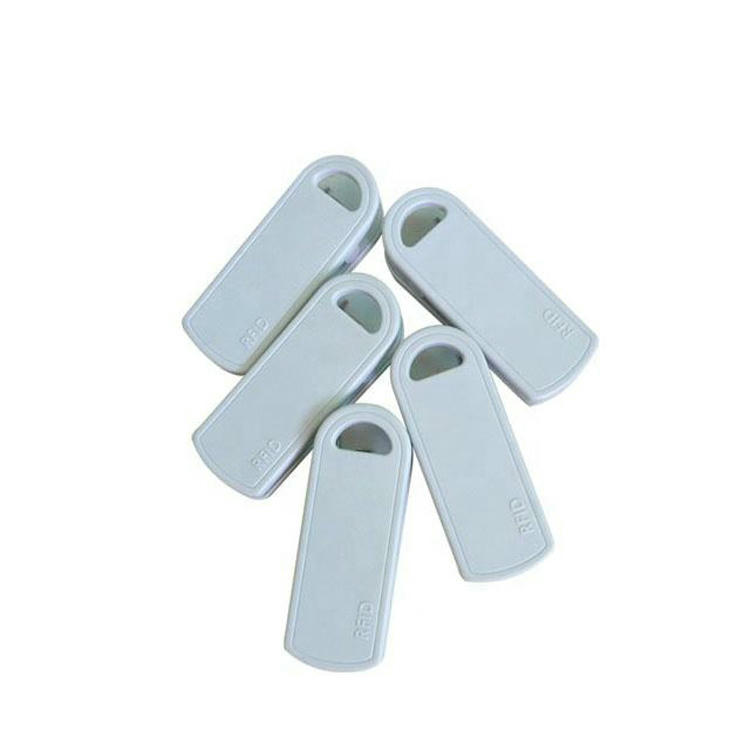 Esta imagem mostra cinco tags RFID brancas com clipe SV-014 dispostas em leque para apresentar o formato frontal e a abertura da ranhura.