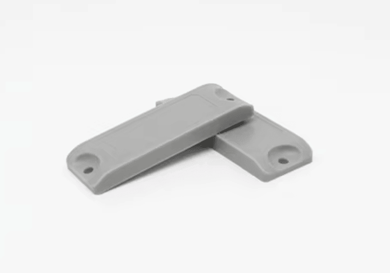 Tags RFID ABS compactas para metal em ativos industriais, mostradas com detalhe de logotipo gravado para aplicações RFID em metal.