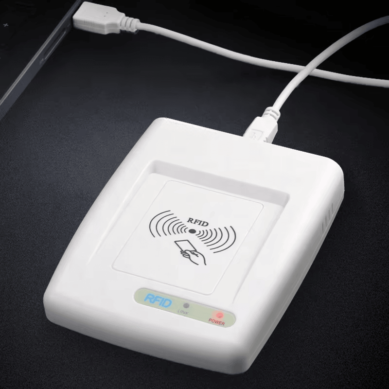 Esta foto mostra o leitor RFID HF RC200U conectado por cabo USB a um computador de mesa para demonstrar a operação alimentada e a conexão de dados.