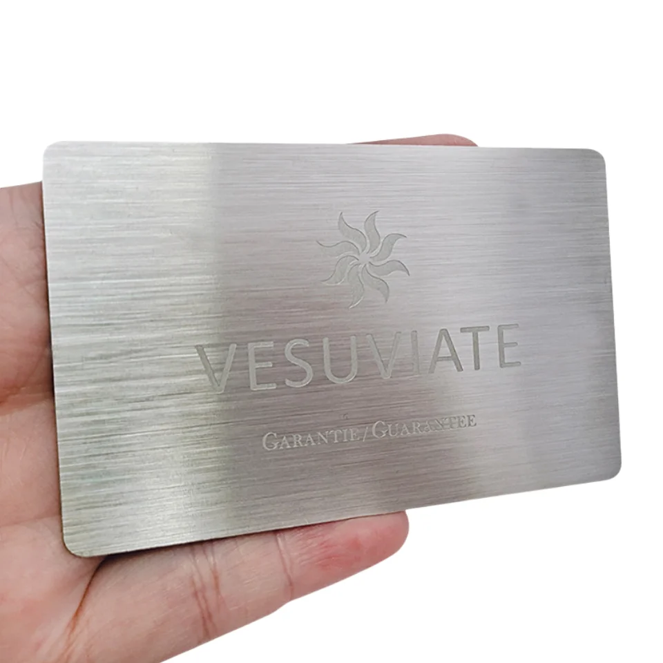 Cartões de visita em metal gravado personalizados apresentados com amostra de design personalizado para aplicações de cartões metálicos.