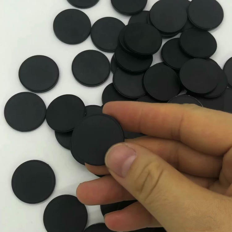 Foto em ângulo alto de várias tags RFID pequenas em disco de diferentes cores usadas em sistemas de gestão de patrulha de segurança.
