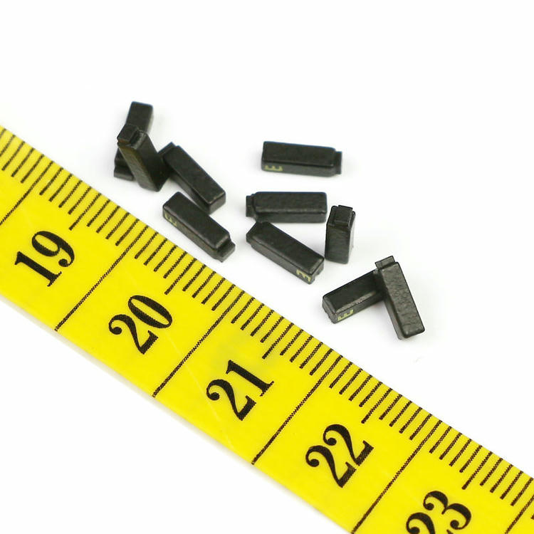 A tiny C0602-1 ceramic RFID tag is held on a fingertip to visually demonstrate its miniature 6x2mm dimensions.